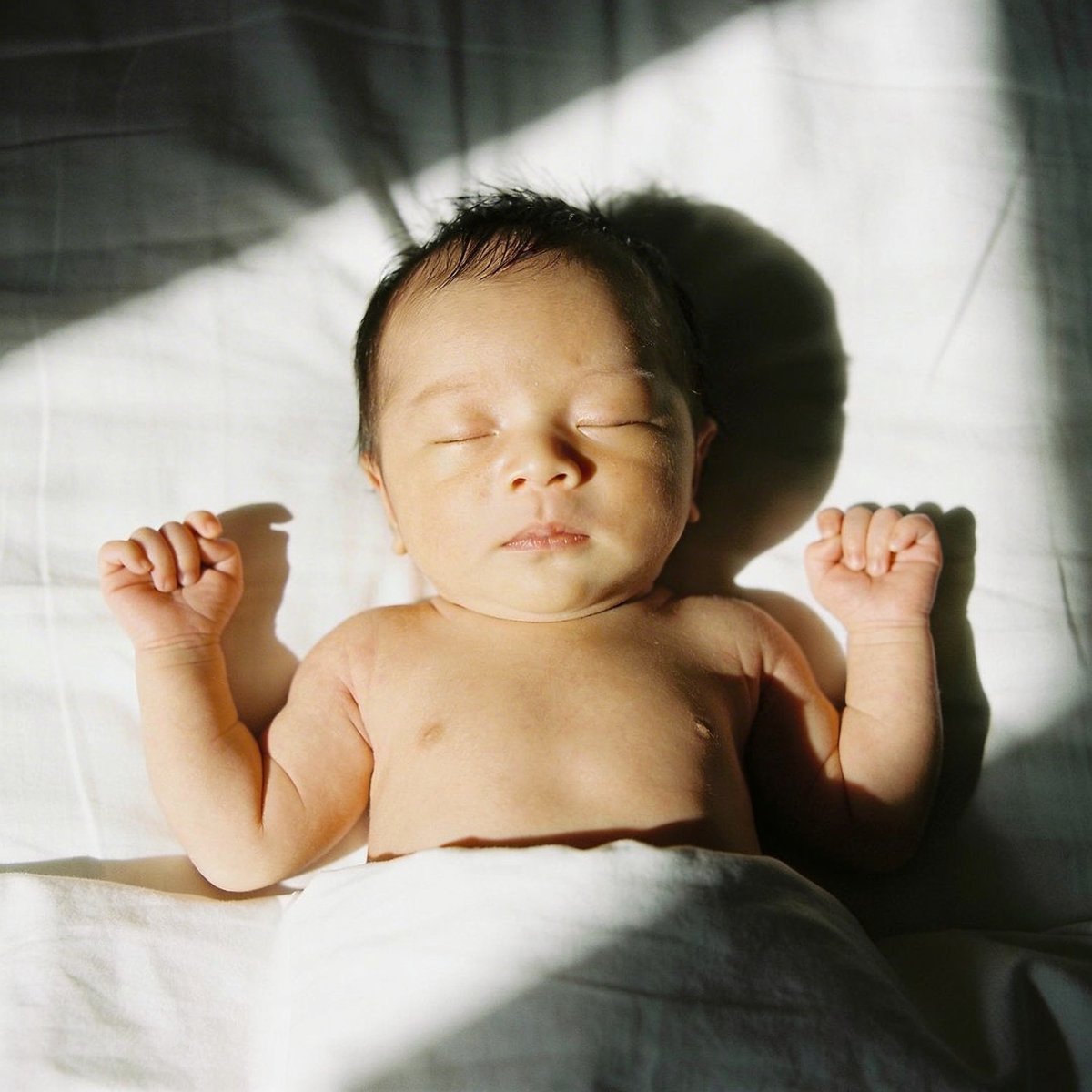 Bebé fotografiado con luz natural suave junto a una ventana en ángulo de 45 grados